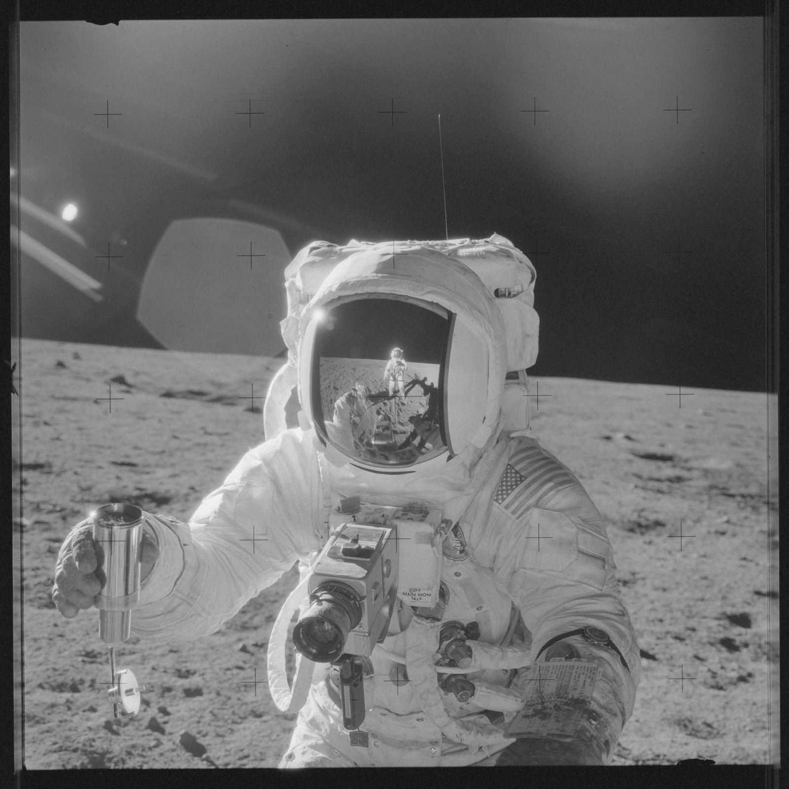 宇航员 Alan Bean 手持样本容器,面罩中映出拍摄者 Conrad